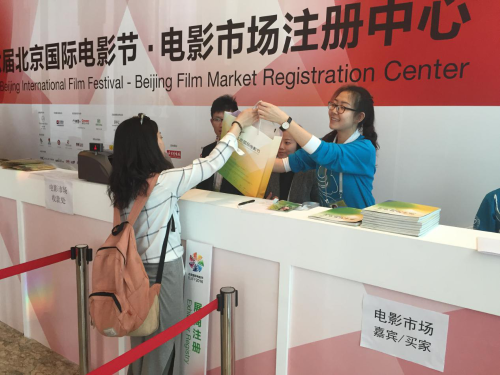 注册中心志愿者为展商派发资料袋